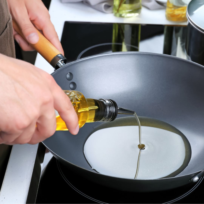 personal pouring cooking oil into pan