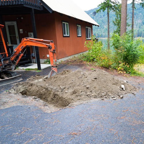 an excavator digs a whole for a septic tank