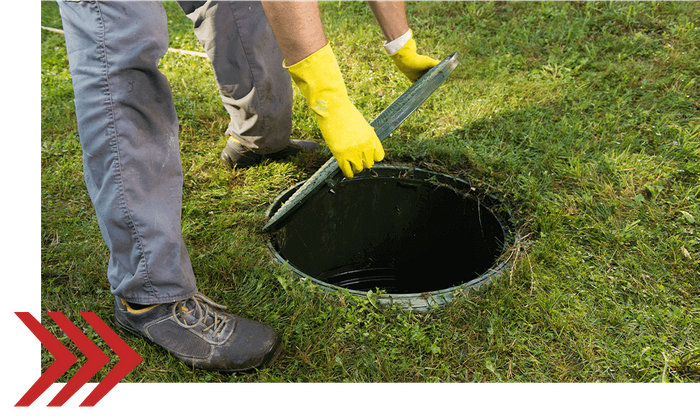 a person opening a septic cover a person opening a septic cover