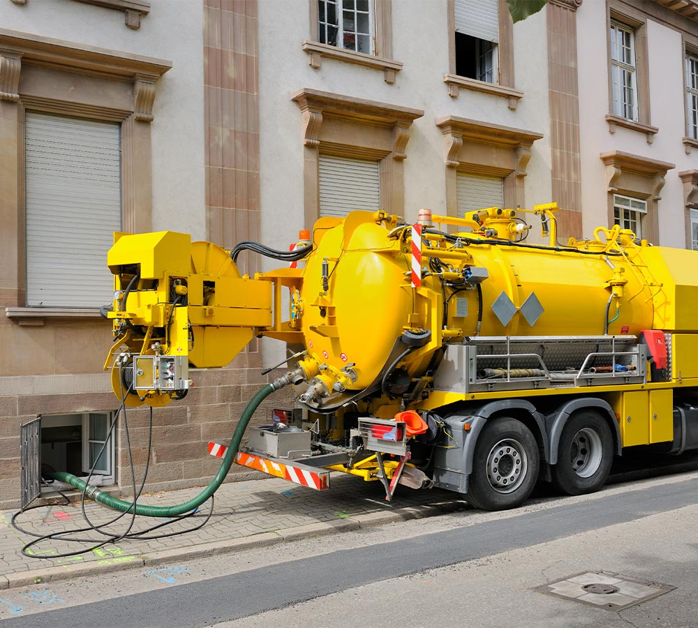 a septic truck with a hose in a bottom window