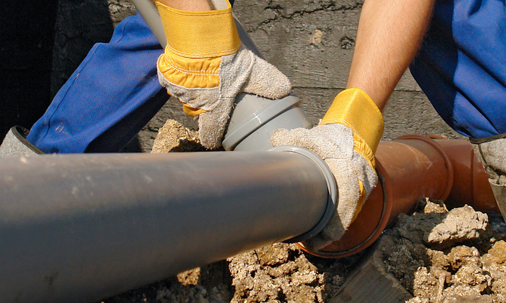 Image of a worker replacing a sewage pipe
