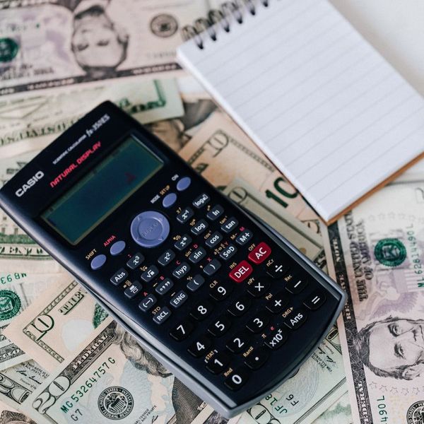 pile of money under a note pad and calculater maint&install4.jpg