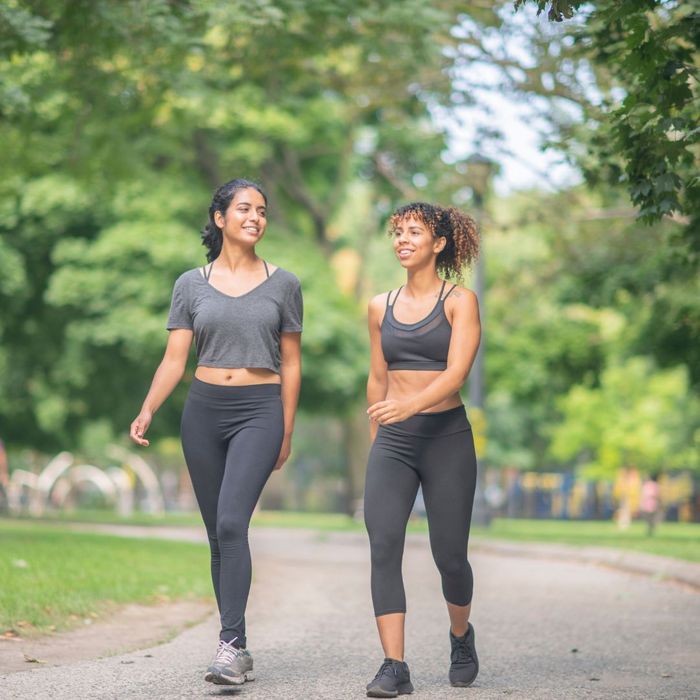 Two people wearing exercise clothing walking outside together