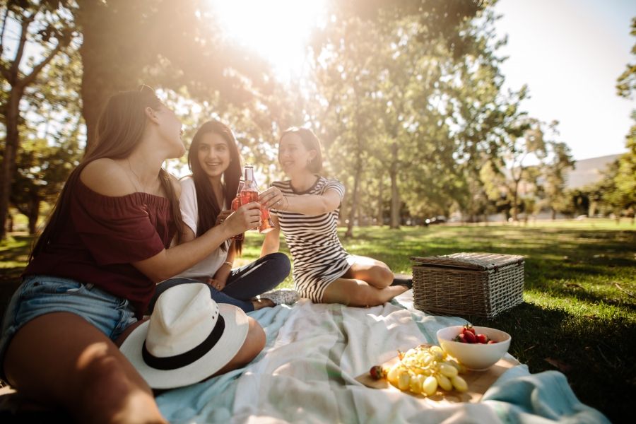 Girls enjoying a picnic on a sunny day in a park