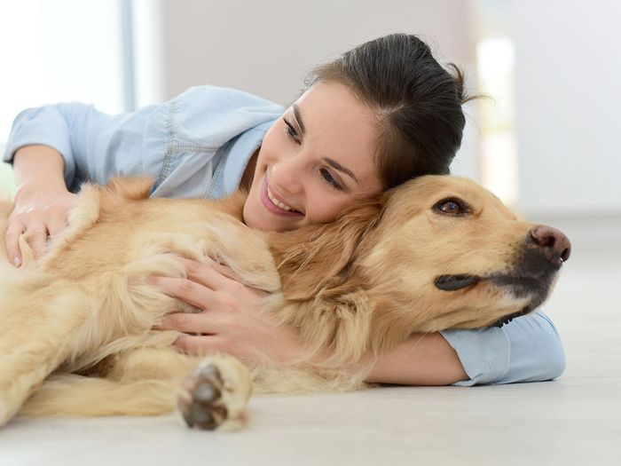 woman smiling while hugging dog