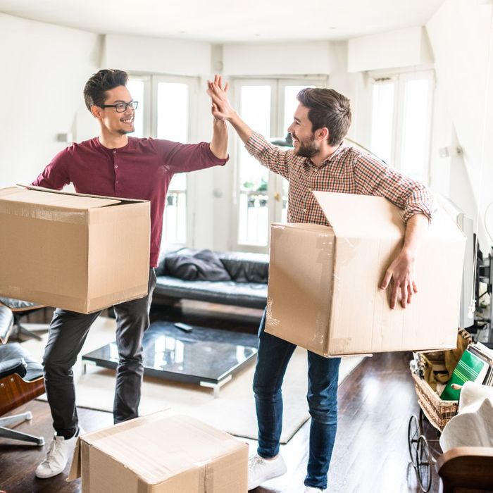 Two people high-fiving while holding a moving box