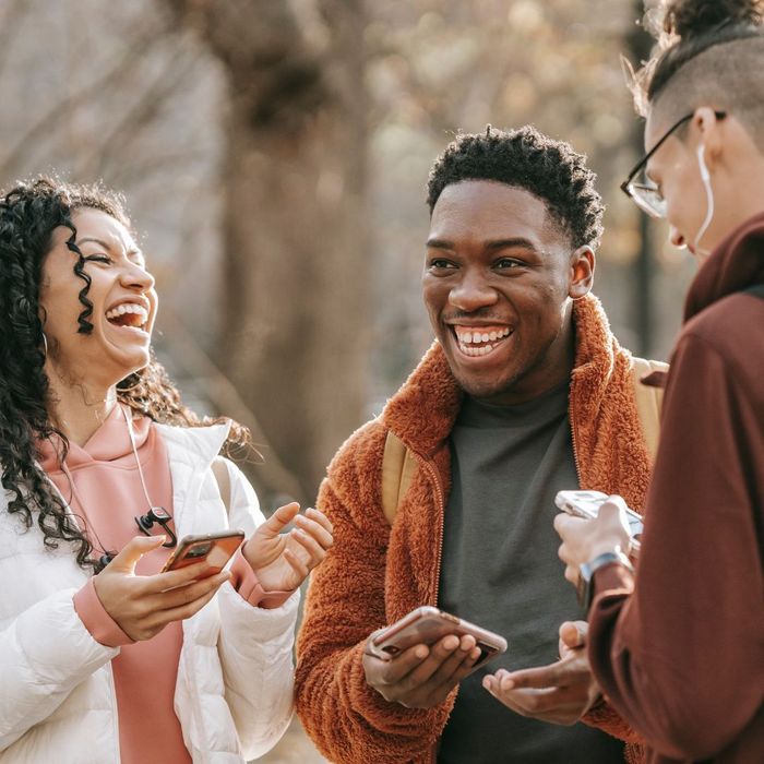 happy friends laughing with phones out, sharing contact info etc