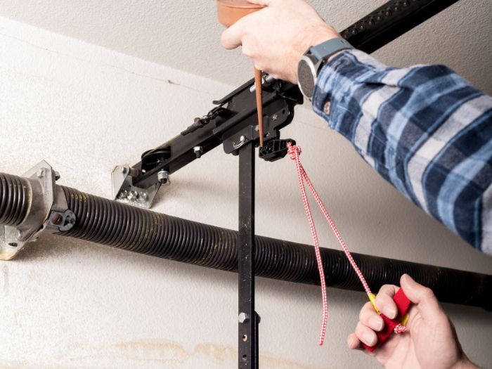 Person repairing a garage door. 