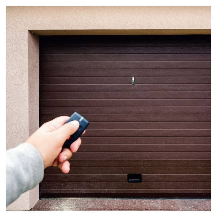 hand clicking garage door opener