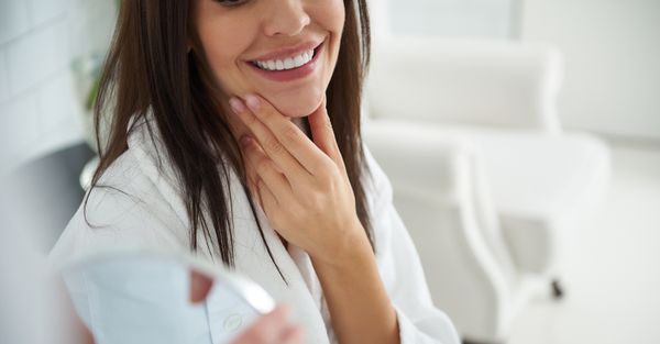 A woman looking in the mirror after a facial