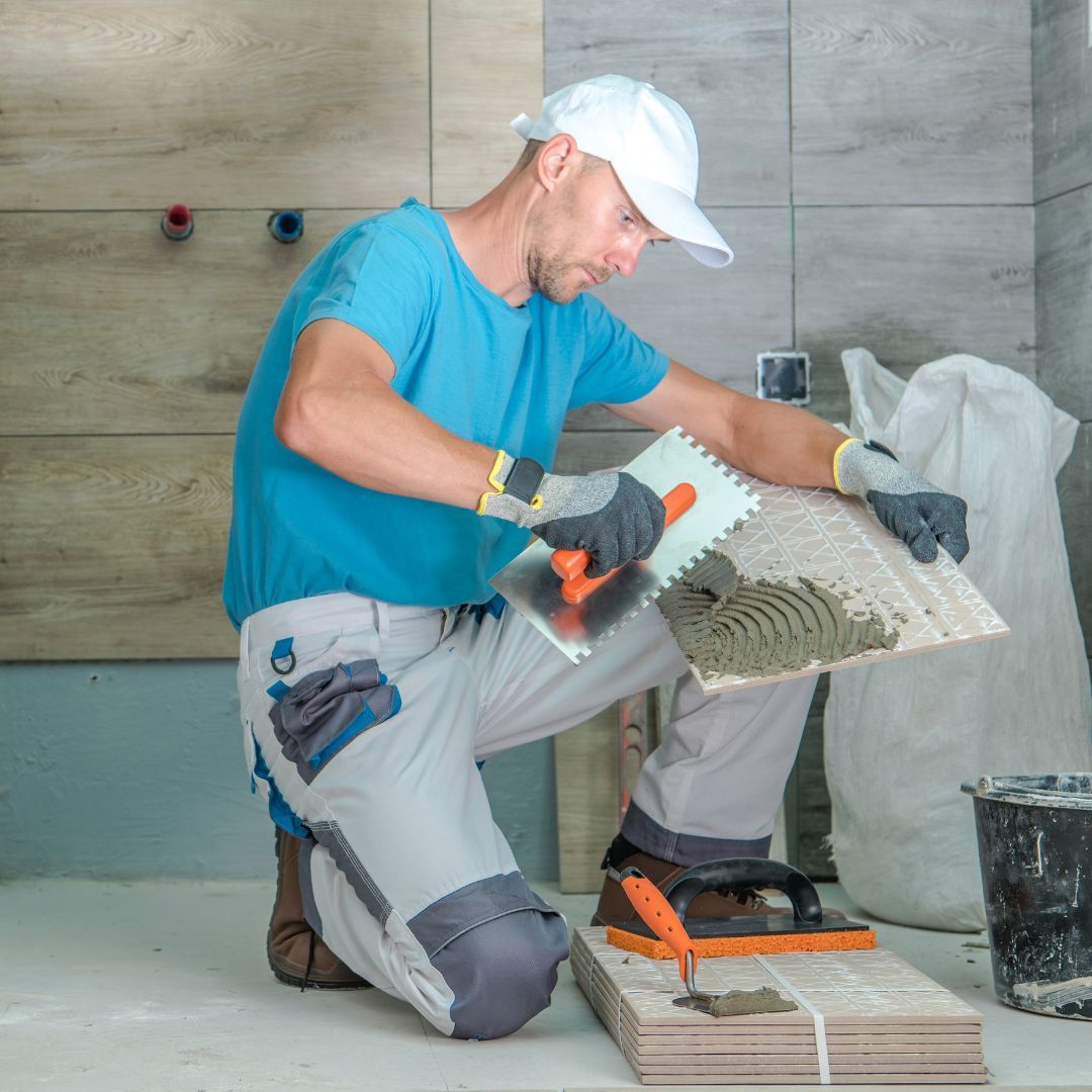 contractor laying tile in bathroom