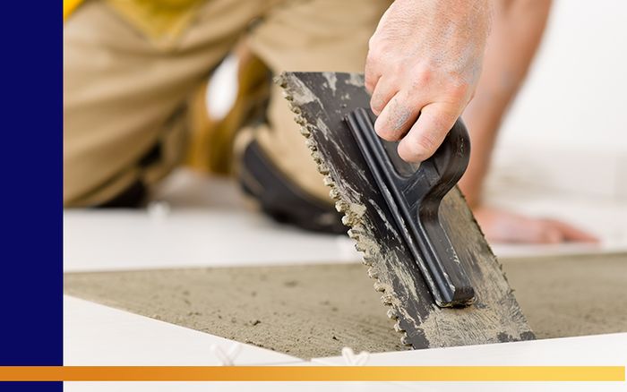 A handyman working on a tile floor