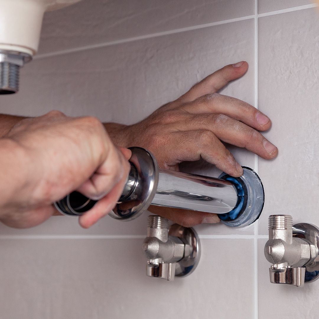 Image of a man plumbing a sink