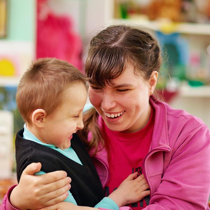 smiling woman hugging a boy with special needs