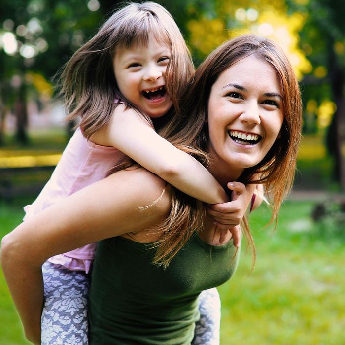 smiling mother holding daughter with special needs