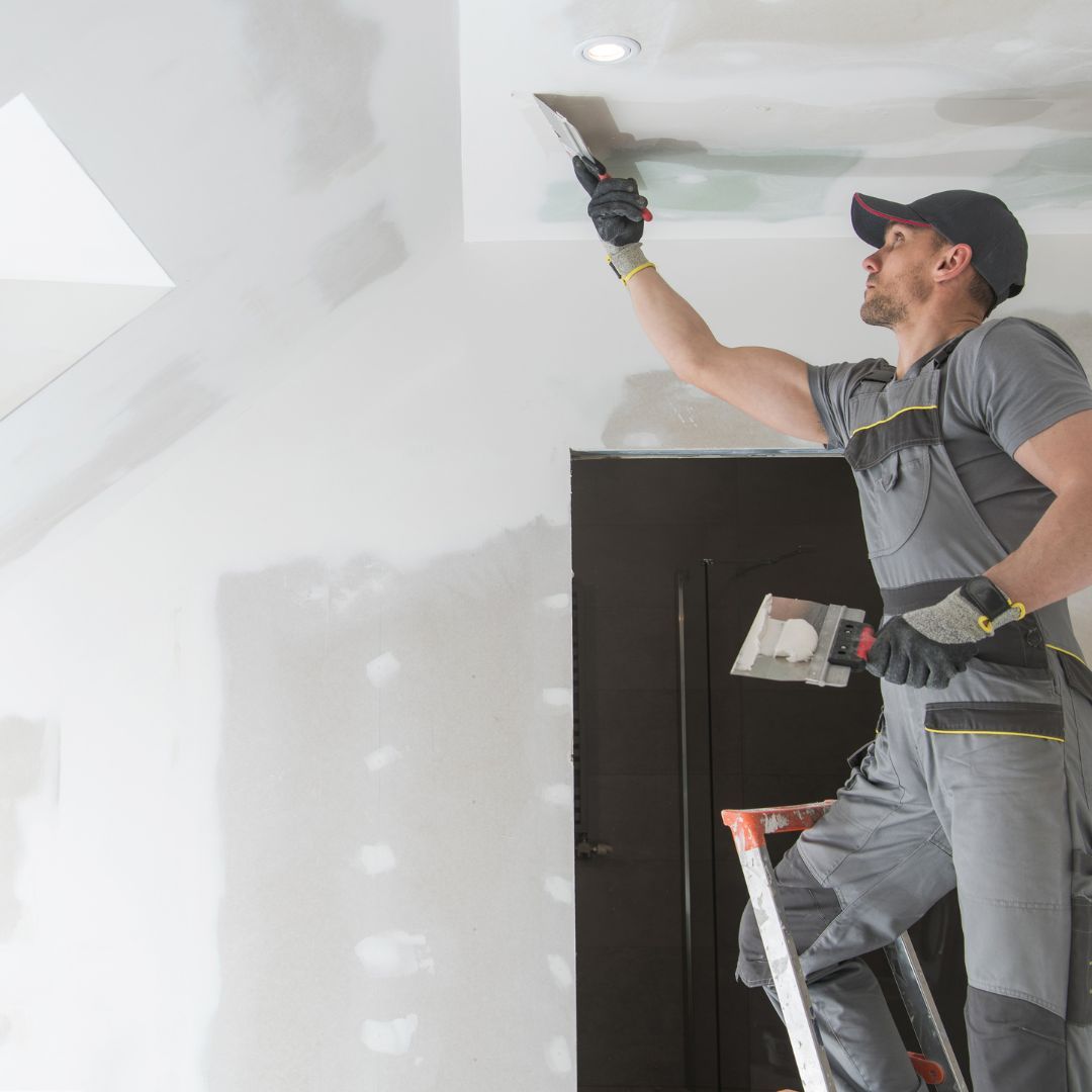 Man applying drywall finish to ceiling 