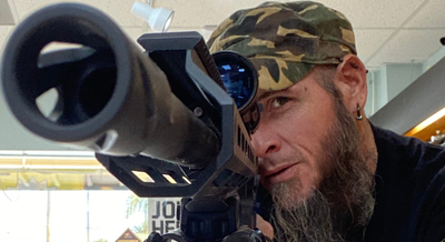 a man looking through a rifle scope