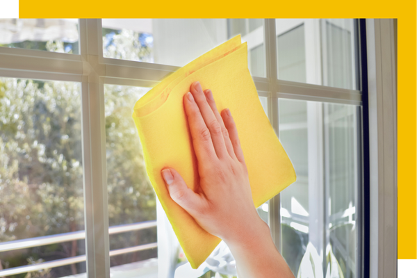 person wiping down a glass surface. 