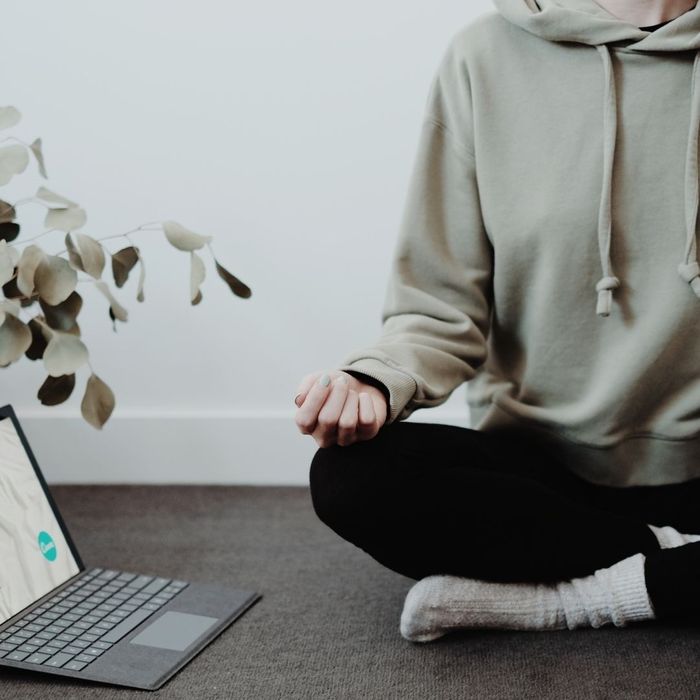 An individual meditating by their computer