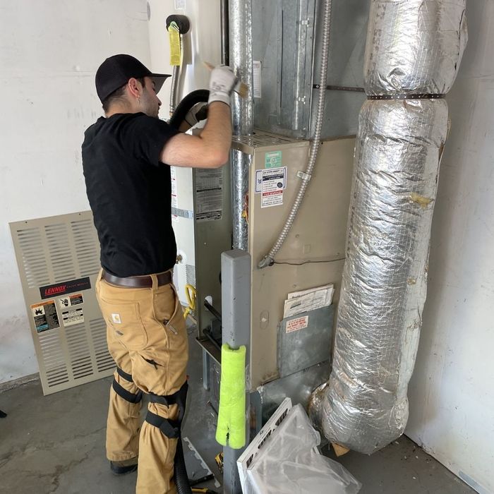 Tech repairing a residential HVAC unit