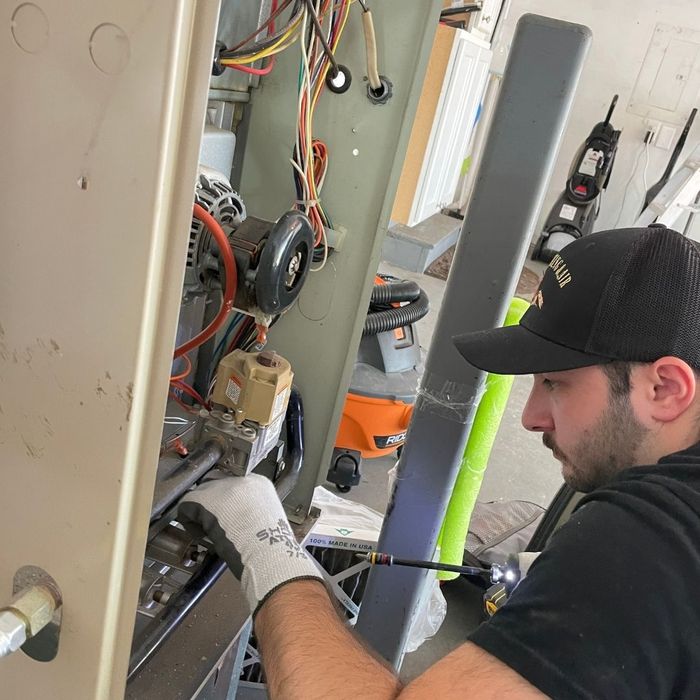 Image of one of the workers performing maintenance on an hvac system.