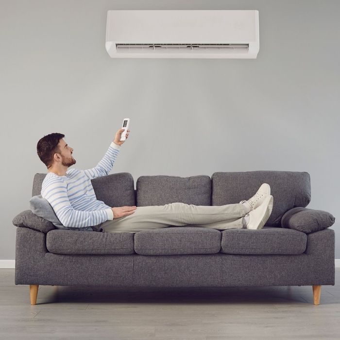 Person turning on his ductless ac unit