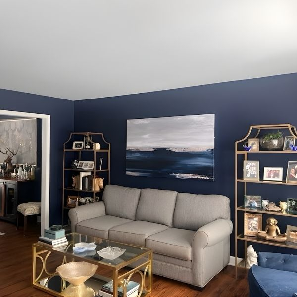 Living room with navy painted walls, and gold accent furniture.