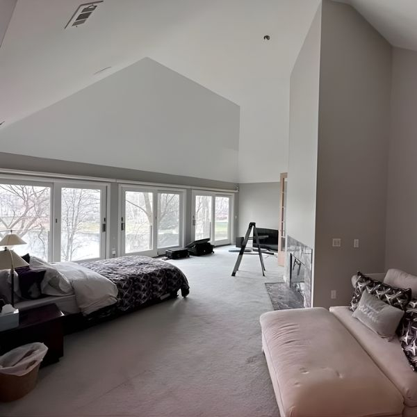 Muted grey painted walls in a bedroom with large windows.