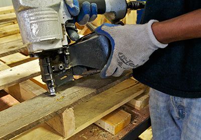 man nailing wood pallet