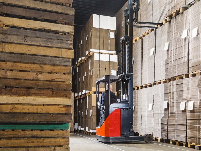 Man operating forklift in warehouse.