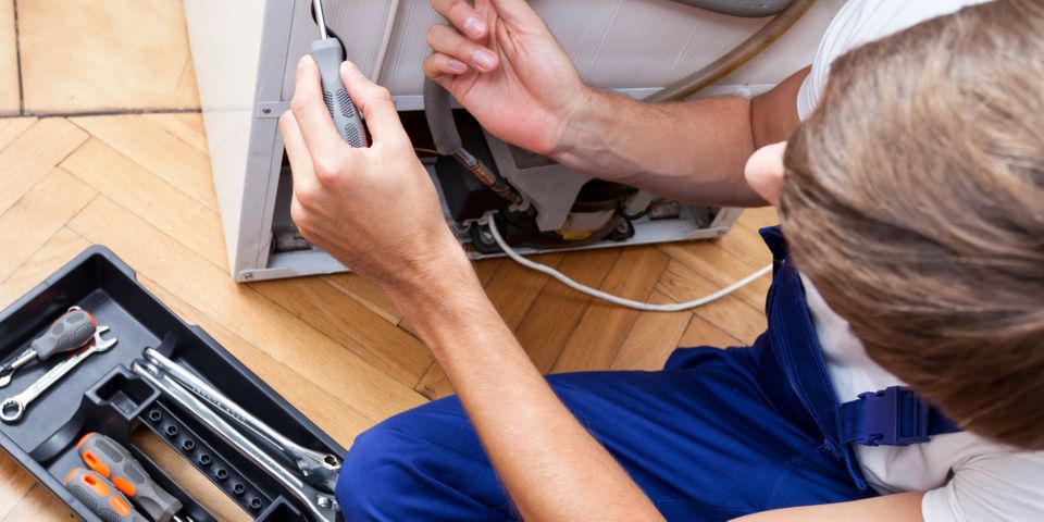 man repairing fridge