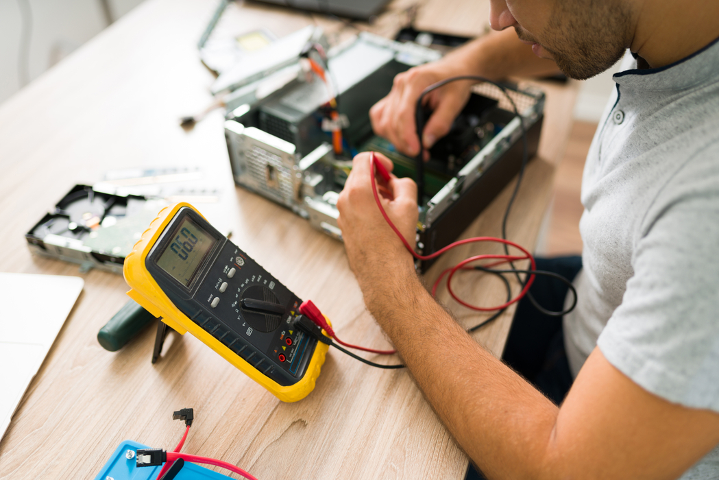 technician-using-multimeter-measure-voltage-broken-computer-young-man-checking-computer-connections-repair-shop.jpg