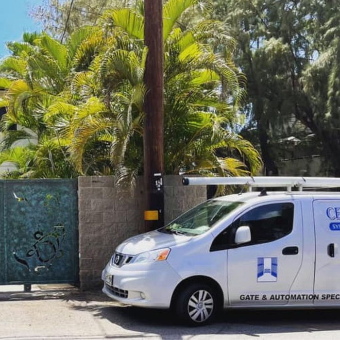 White service van parked next to decorative gate.