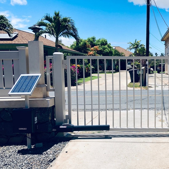 White automatic driveway gate with a solar panel.