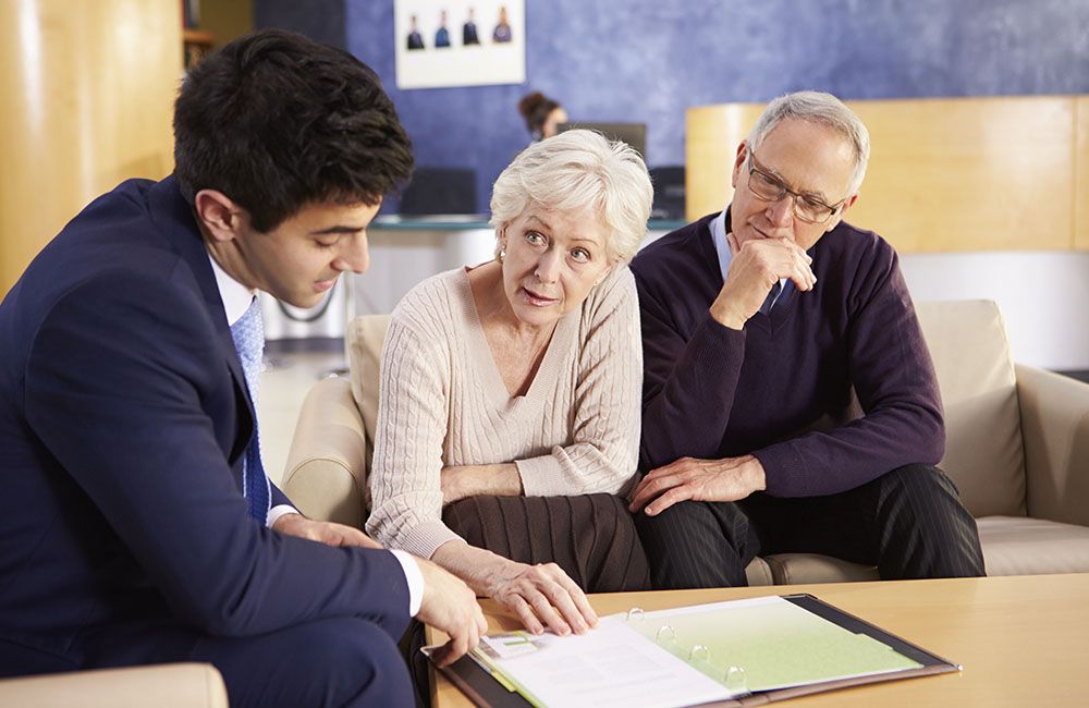 Elderly couple talking with consultant