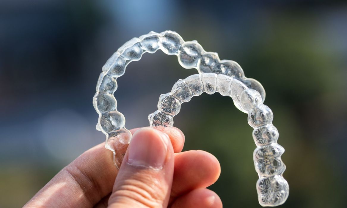 person holding two invisalign trays