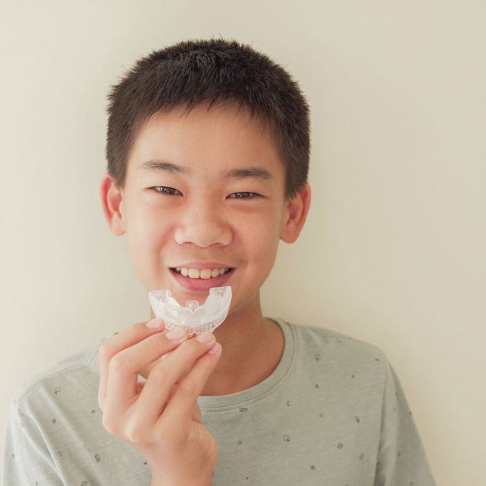 teenager putting on Invisalign