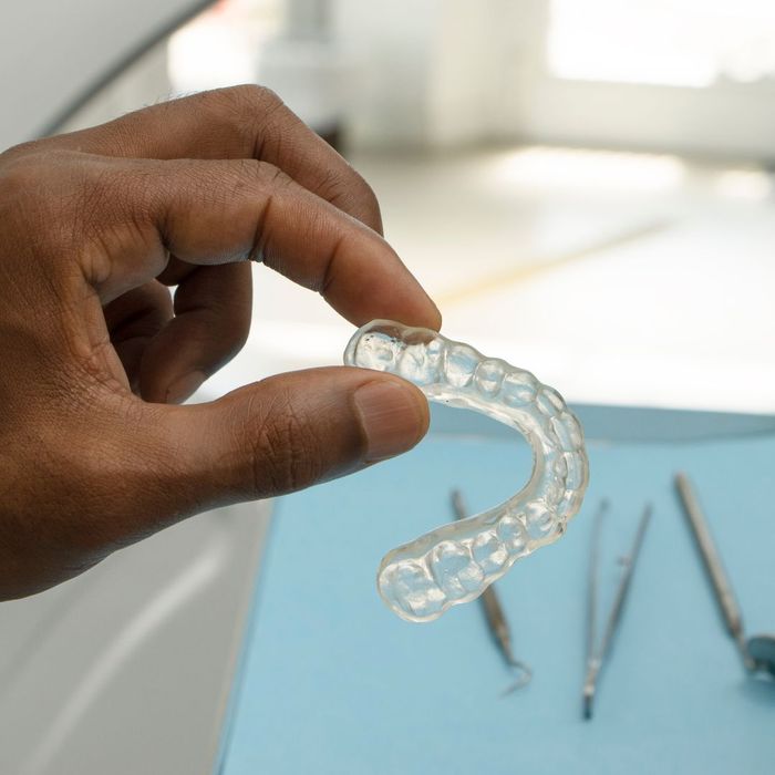 person holding Invisalign tray