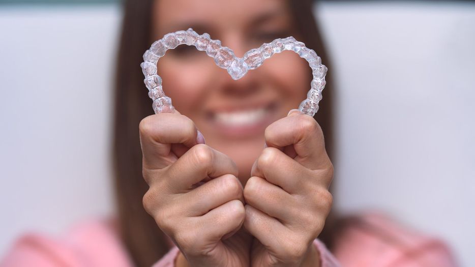 Invisalign aligners held together in the shape of a heart