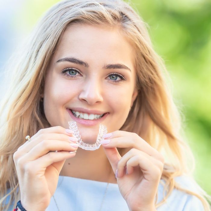 teen putting on clear aligner