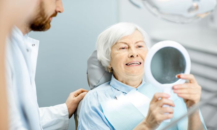 older woman smiling in dental chair