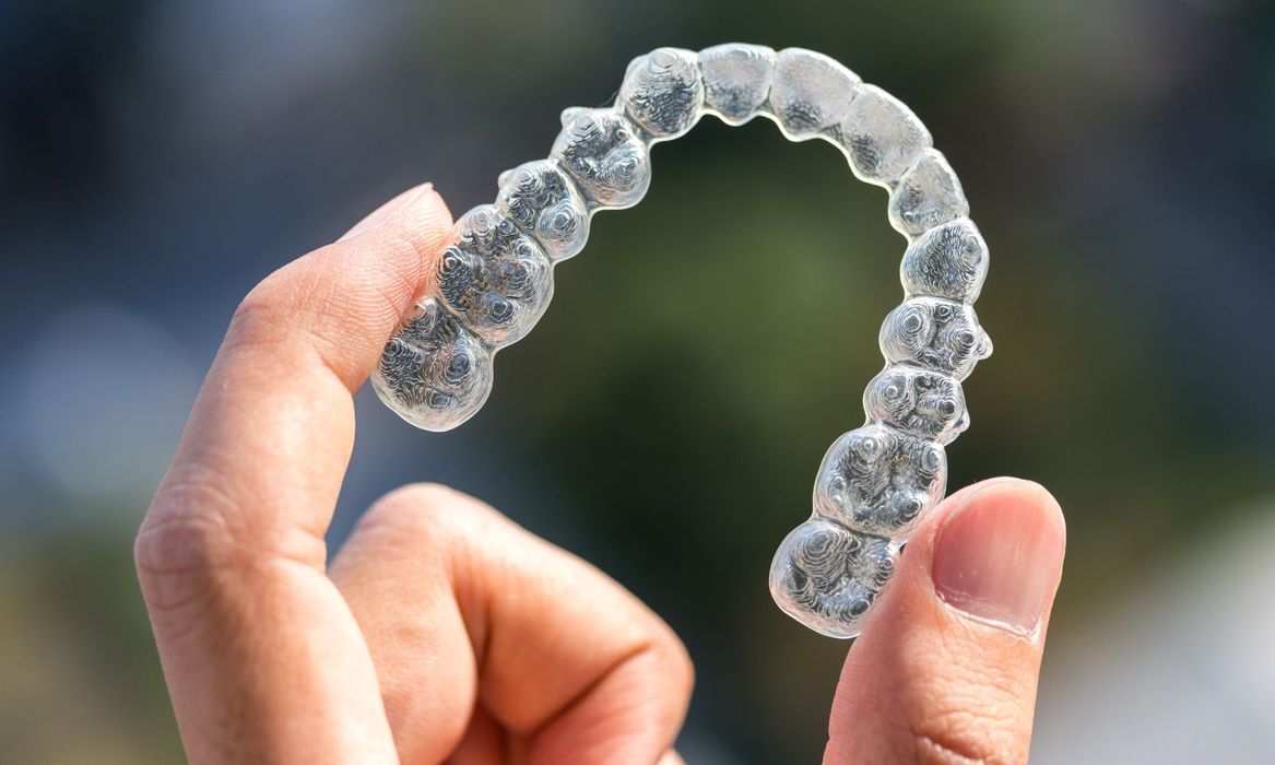person holding an invisalign tray