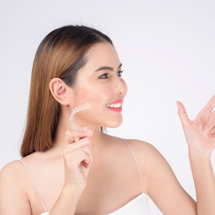 woman posing with invisalign in hand
