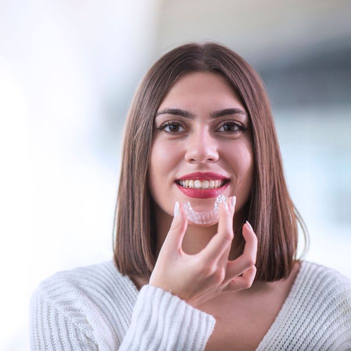 woman putting on invisalign 