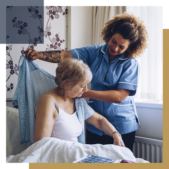 Caregiver helping a woman get dressed