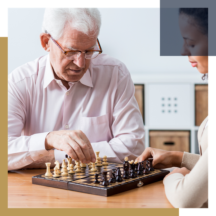 Caregiver playing chess with a senior man