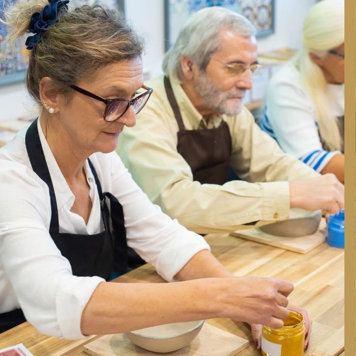 elderly couple painting during a pottery class