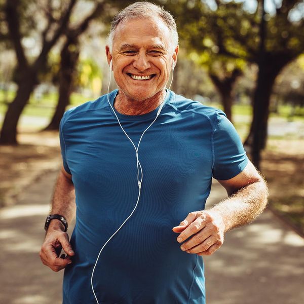 Happy man jogging while listening to headphones