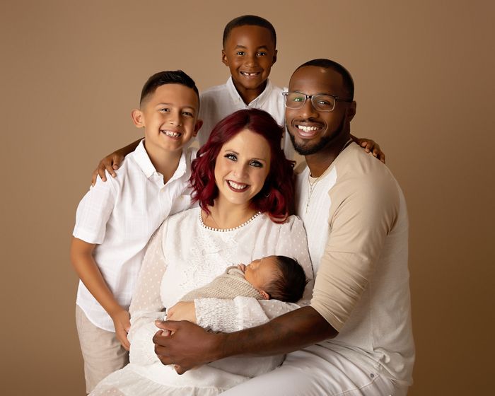 Family with Newborn Baby on Tan Background Family with Newborn Baby