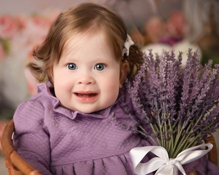 Baby girl in a lvender dress holding flowers during a milestone session by Kelly Saxon Photography, professional baby photographer in Murfreesboro, Tennessee. Lavender Baby Milestone Portrait-Kelly Saxon Photography
